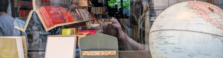 My reflection in the window of a stationery store in Brussels. I'm wearing my cap, holding my phone, and admiring the many puzzling and lovely objects on display.